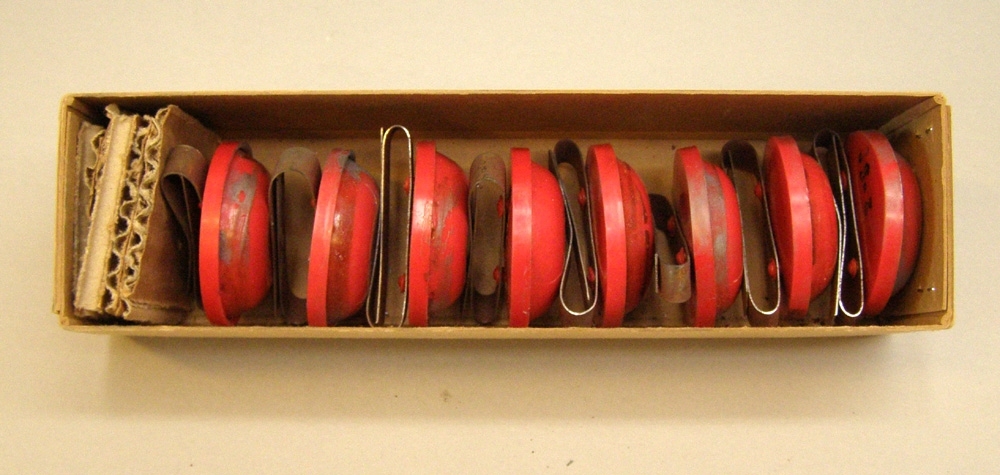En kartong med åtta knalldosor.
Användes för att varna tåg vid fara.
Dosorna är av röd plast och normalt fyllda med krut.
Lades ut på rälsen och fästes med ett platt metallband på rälsen.
Dessa dosor är desarmerade.
