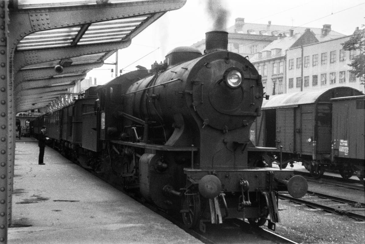 Damplokomotiv type 33a nr. 300 med persontog retning Voss, tog 618, på Bergen stasjon. Elektrisk lokomotiv type El 9 nr. 2063 medfulgte toget.