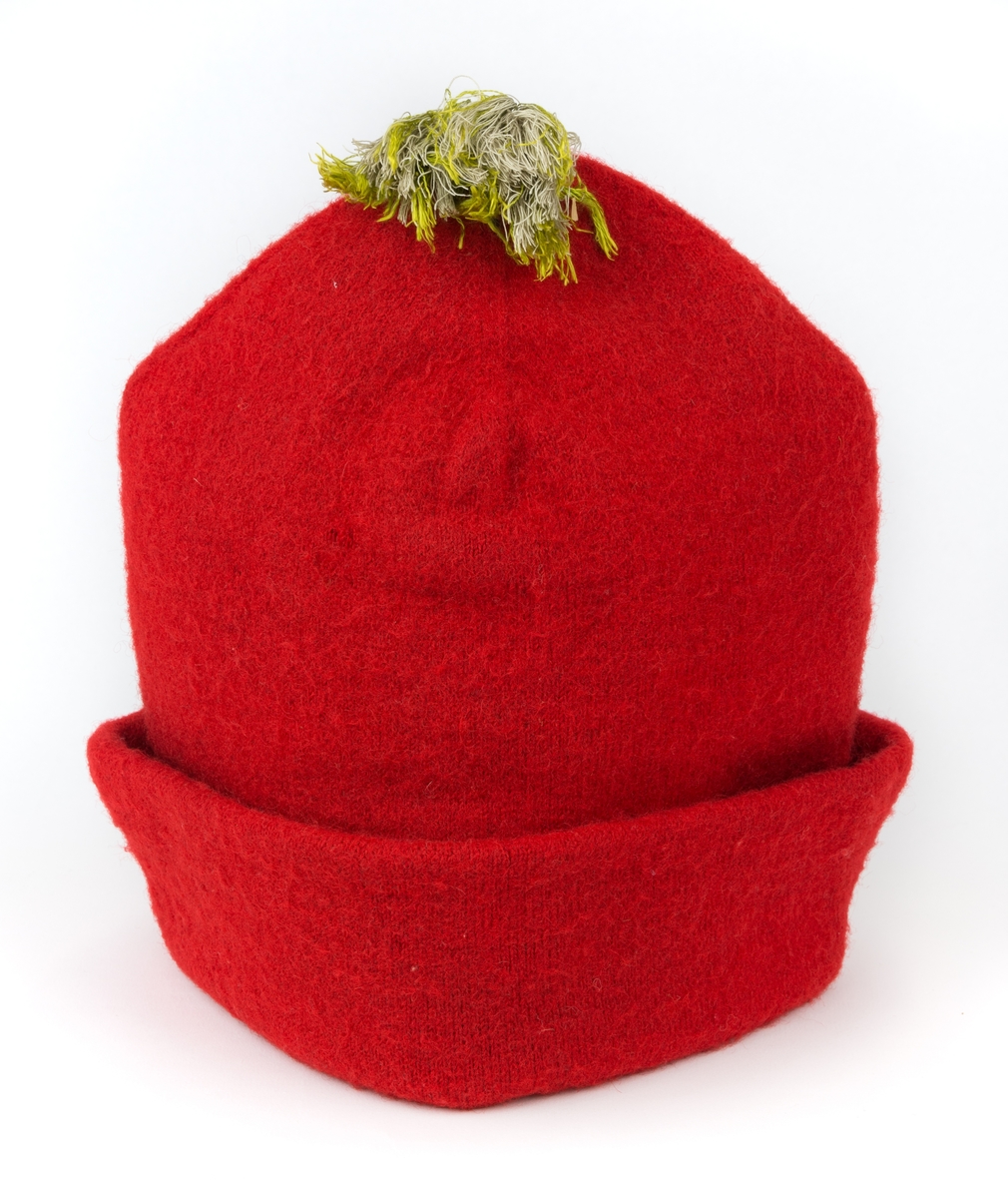 Mansluva, så kallad "rödluva", stickad av rött ullgarn, dubbel. Filtad och fodrad med linnelärft. Grön silkestofs.