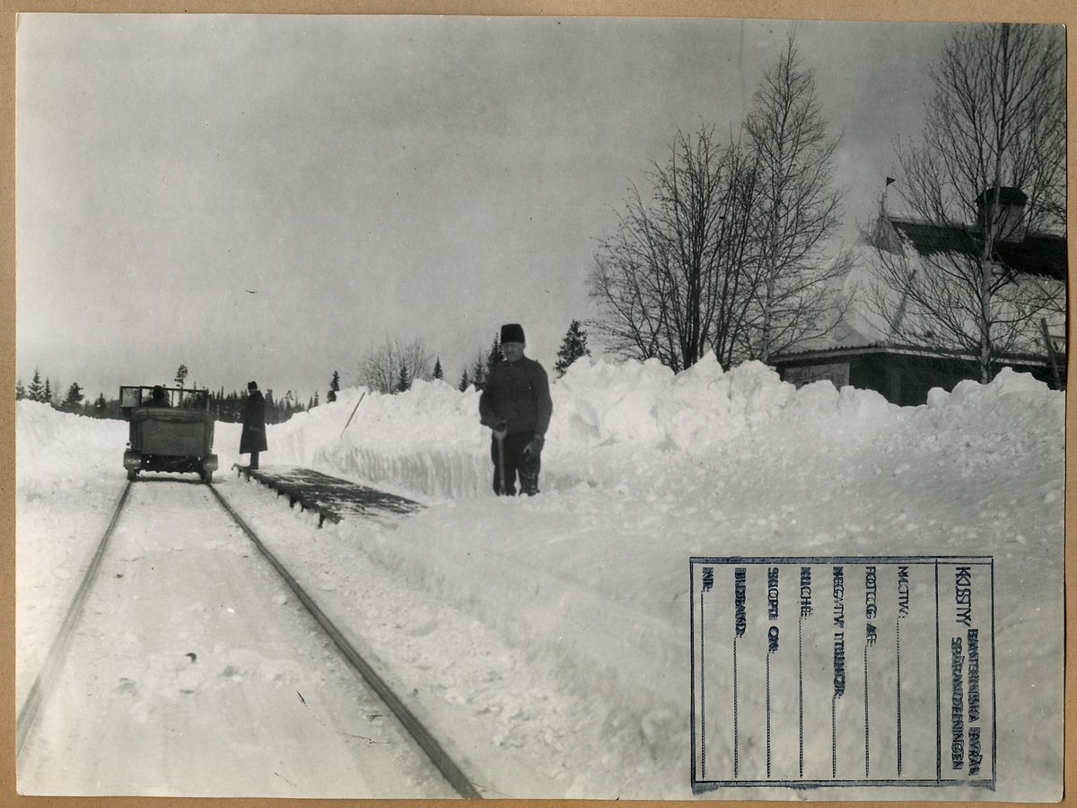 Snöskottning av plattform vid Gråtbäck Station. Längre bort en motordressin, så kallad "bil-dressin".