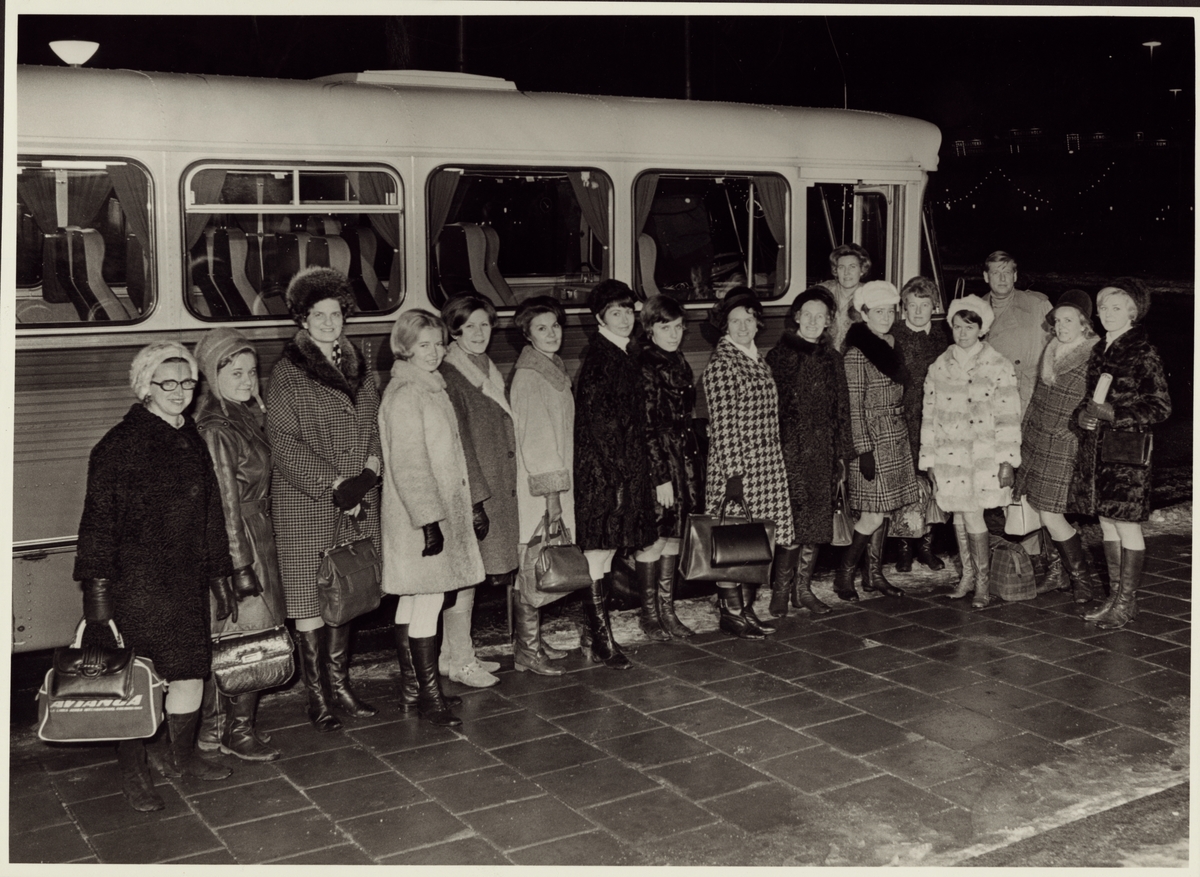 Vinterklädda kvinnor utanför buss.
