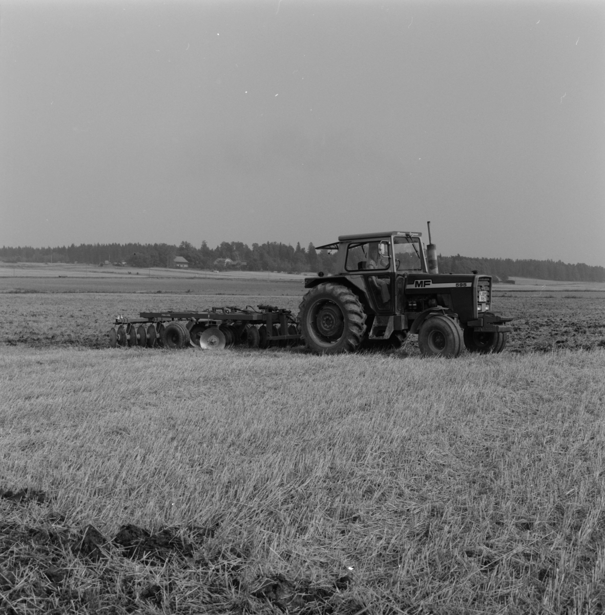 Jordbrukare Kerstin Leijon kör upp den nyskördade åkern med en tallriksharv, Stora Bärsta, Uppsala-Näs socken, Uppland september 1981