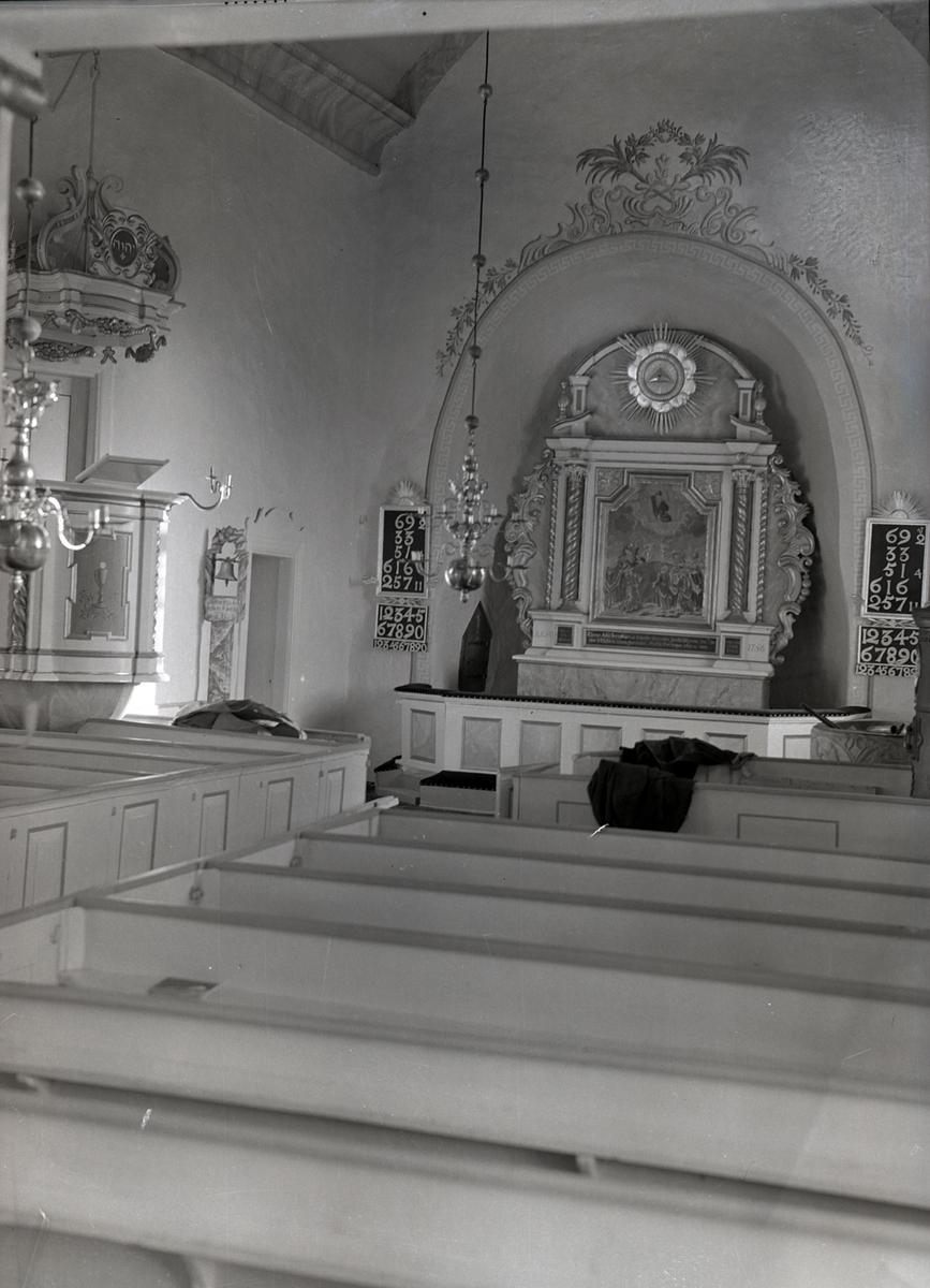 Interiör av Egby kyrka, mot altaret. På bilden syns predikstol med baldakin och altartavlan samt psalmtavlan.