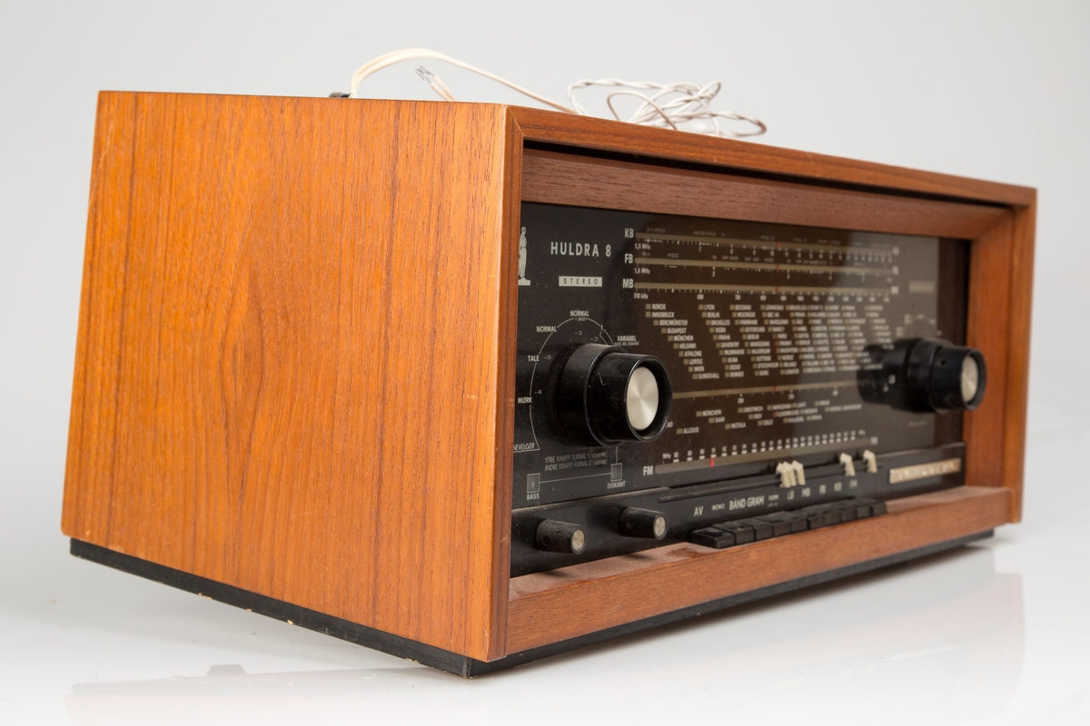 Radioapparat med to eksterne høyttalere. Rektangulært teak-finert kabinett, sort glassfront.