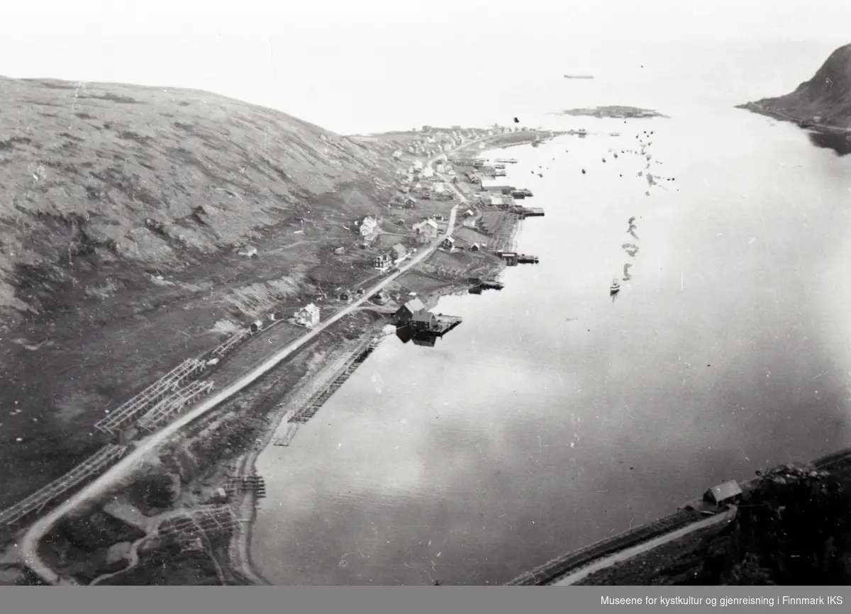 Nordvågen. Oversiktsbilde med bebyggelse, kaianlegg og fiskehjeller. Holmen i bakgrunnen. Ca. 1934.