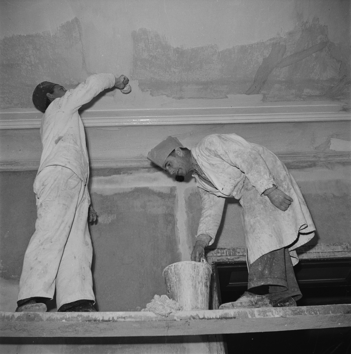 Två män målar ett tak, restaurering inför Östgöta nations 300-årsjubileum, Uppsala 1946