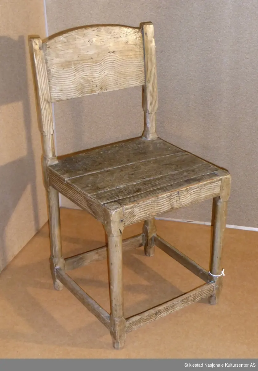 Stol i renesanselignende stil, ca. 1700. Sete laget av to bord, sprukket. Dreide (eller spikket/teljet) føtter som er tappet inn og naglet til sidesarg/ramme. Ryggbrett er et bord med buet topp. Grovt åringsmalt. Lavt sprossverk (avstivere). Merket med krittmerke under sete.