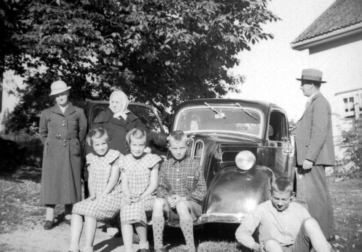 Familie samlet rundt bilen til August Bratteng på Jørstad søgard. Tvillingene Sigrun og Astrid Jørstad, f. 1930 foran til venstre på bilen. Stående fra venstre: Kari Bratteng f. Jørstad, Agnete Jørstad og August Bratteng helt til høyre