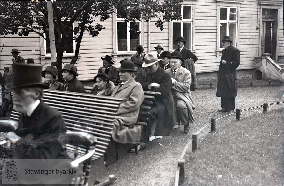 Tilskuere på benker utenfor kommunebiblioteket