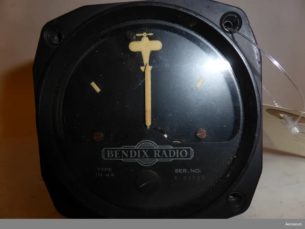 En radiopejl. Den är svart med svagt gul visare, och streck i displayen. Kroppen av föremålet är metallfärgat.

På displayen står det: "BENDIX RADIO TYPE IN-4A SER. NO. 9 04282" I botten av instrumentet finns det inetsat "HICKOK". Det finns också två stämplar där det står: "ELEC. 146" och "SC 645 A"