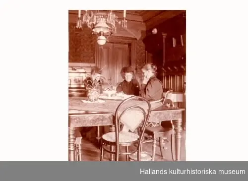 Interiör. Matsalen i Gerlachska huset. Vid bordet sitter två kvinnor och en man och dricker kaffe. Den äldre kvinnan är sorgklädd.