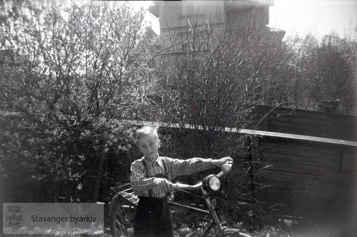 Oskar Andreas Iversen (?) med sykkel i Paradis.Admiral Cruys gate 25 i bakgrunnen.
