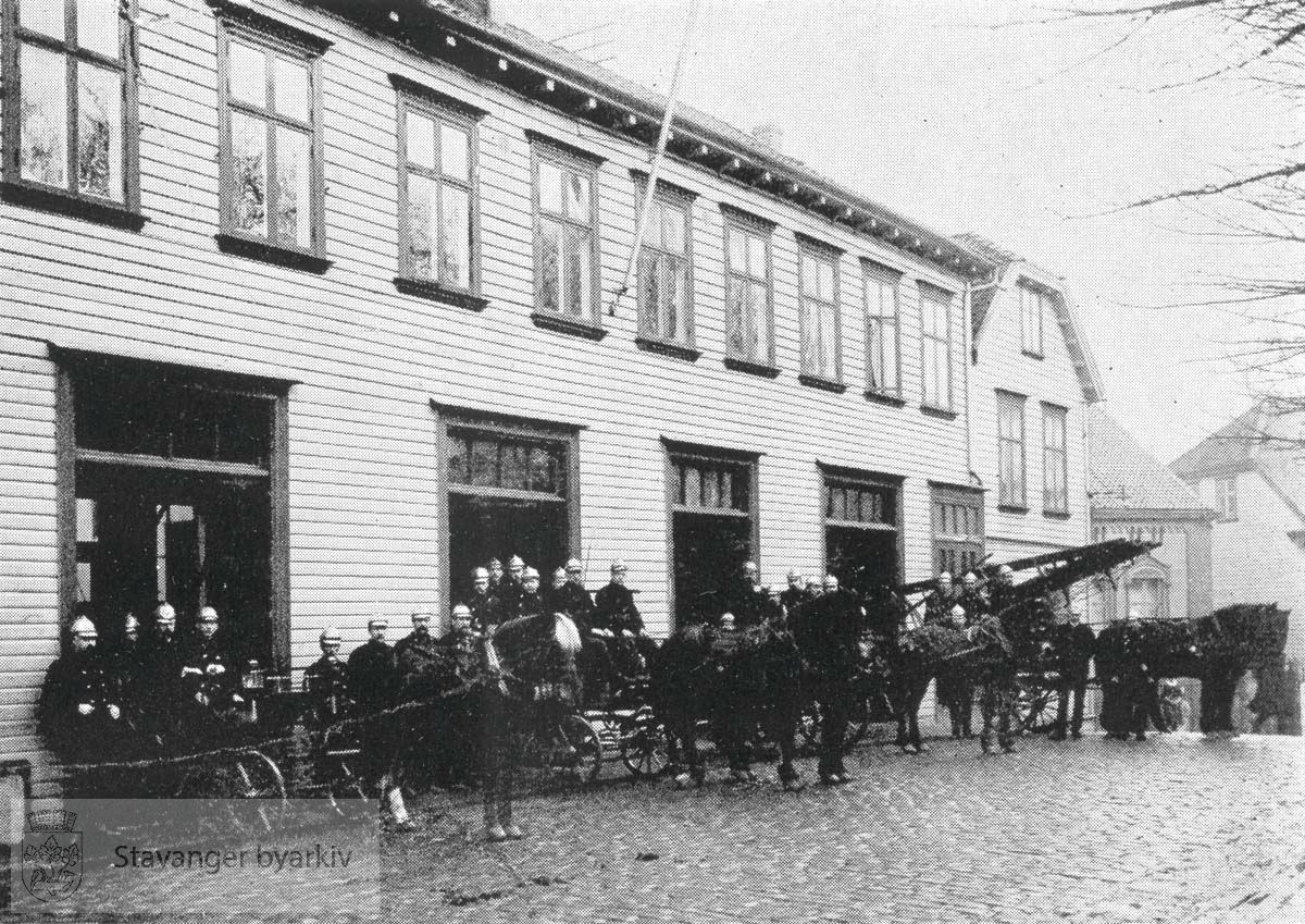 Brannmannskapet oppstilt foran den gamle brannstasjonen i Kongsgata på den nåværende Domkirkeplassen. Den gamle brannstasjonen lå der fra 1883 til 1956.