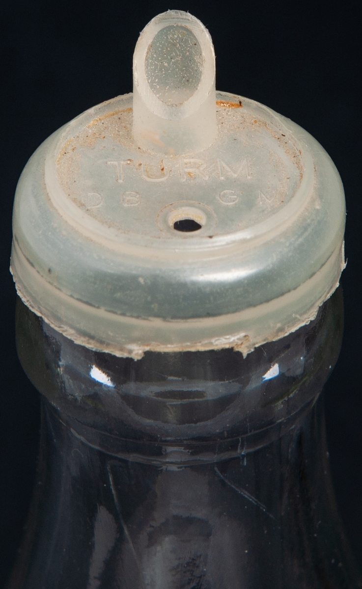 Gräddflaska i pressat glas. Märkt under:
Försedd med plastkapsyl med pip. Kapsylen märkt: TURM.
