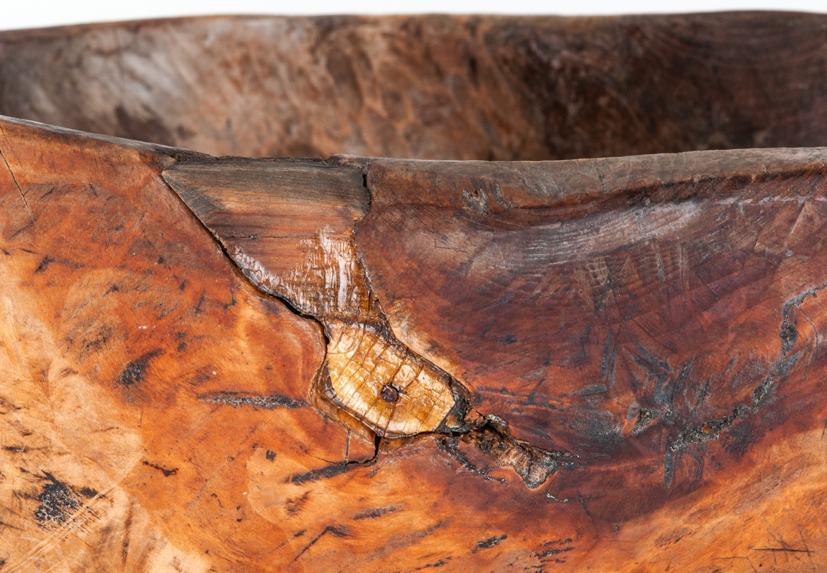 Träskål, vrilskål, snidad av utväxt från träd.
Av björk, urgröpt, naturvuxen, ojämnt trekantig till formen.
Undersidan märkt med karvsnitt: HPS 1864.