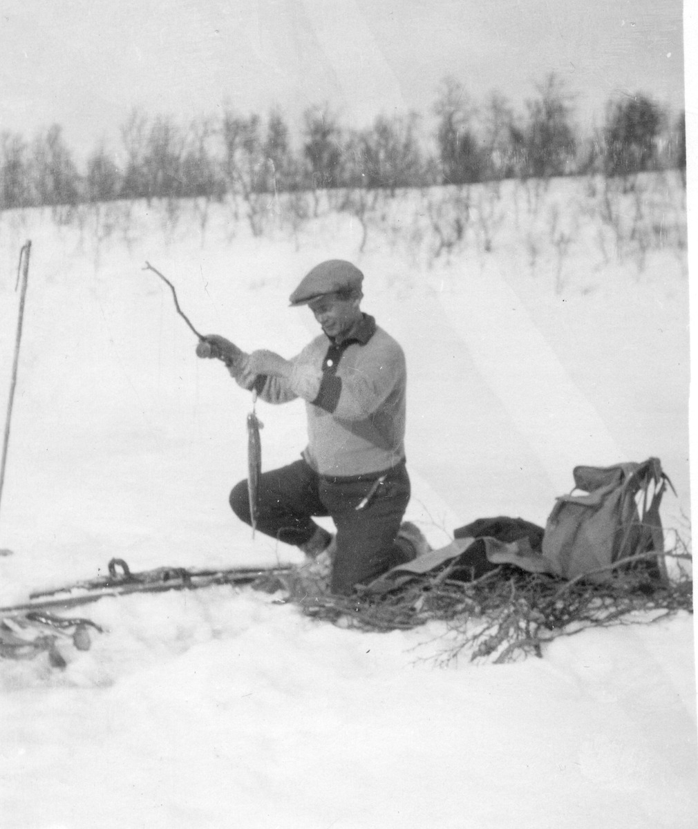 Mann fisker på isen
