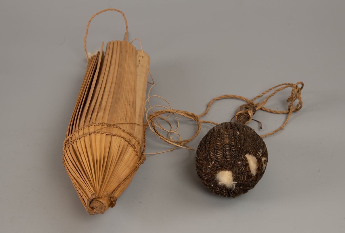 Pilekogger av bambus-spiler, full av piler, et par med bomullsdott i spissen. Tynt flettet tau for feste/oppheng.

Fotografert sammen med tilhørende pose for bomull AAM.19594.D.