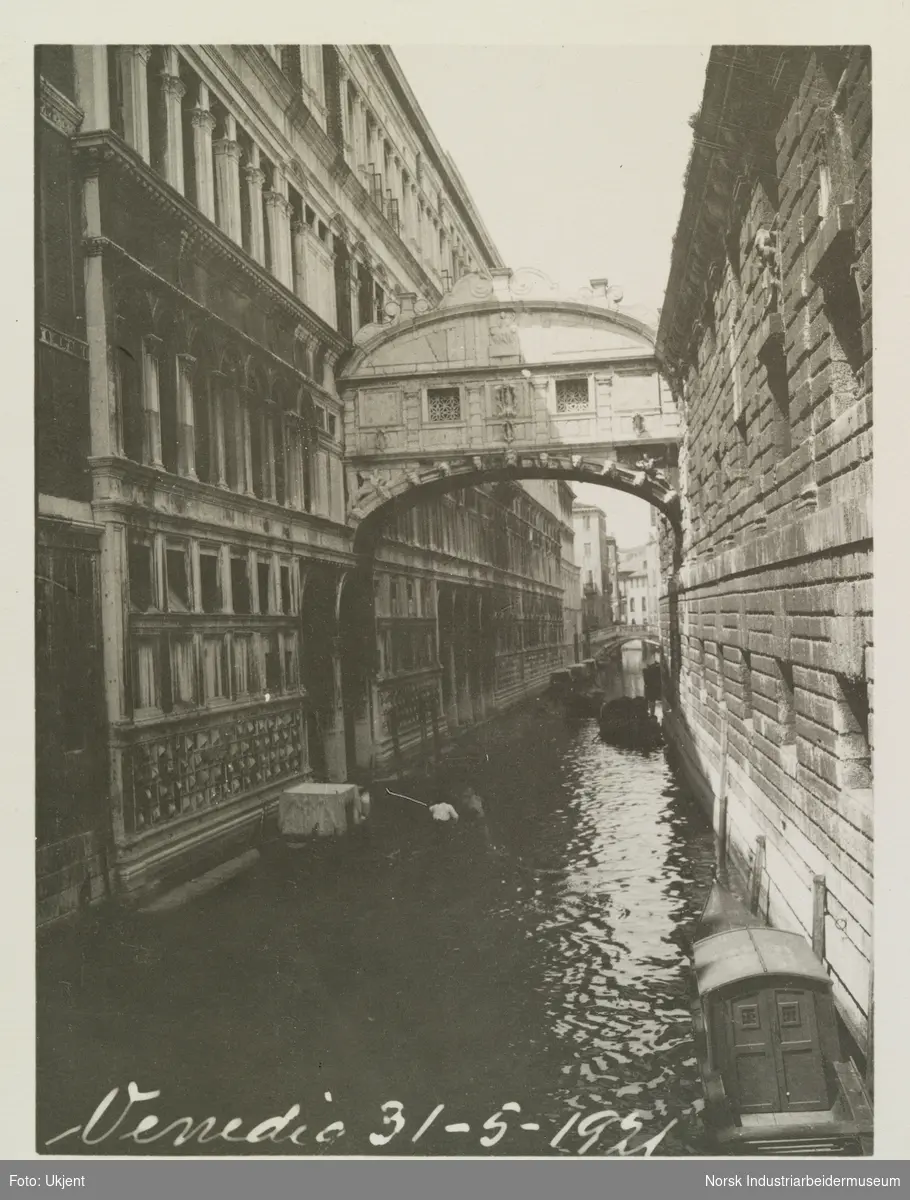 Sukkenes bro mellom Dogapalasset til venstre og fengselet. Smal kanal i Venezia. Bro mellom to bygg og gondoler parkert langs husvegger