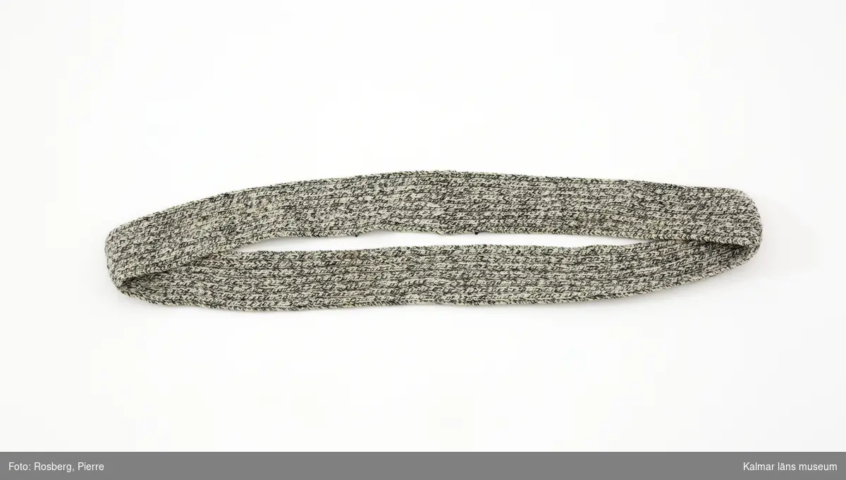Konstverket har titeln Vinterdäck halsduk. Stickad halsvärmare i raggsocksgarn, 2a 2r. 2-2 resår. Stickat i form av en ring för att passa på ett hjul.
