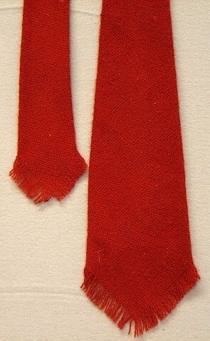 Slips tillverkad av restbitar under krigsåren, 2.a världskriget. Den tillverkades även av gula och blå restbitar. Slipsen syddes även upp fortsättningsvis.Märkt:  "prov som Ströms vill ha slipsen".