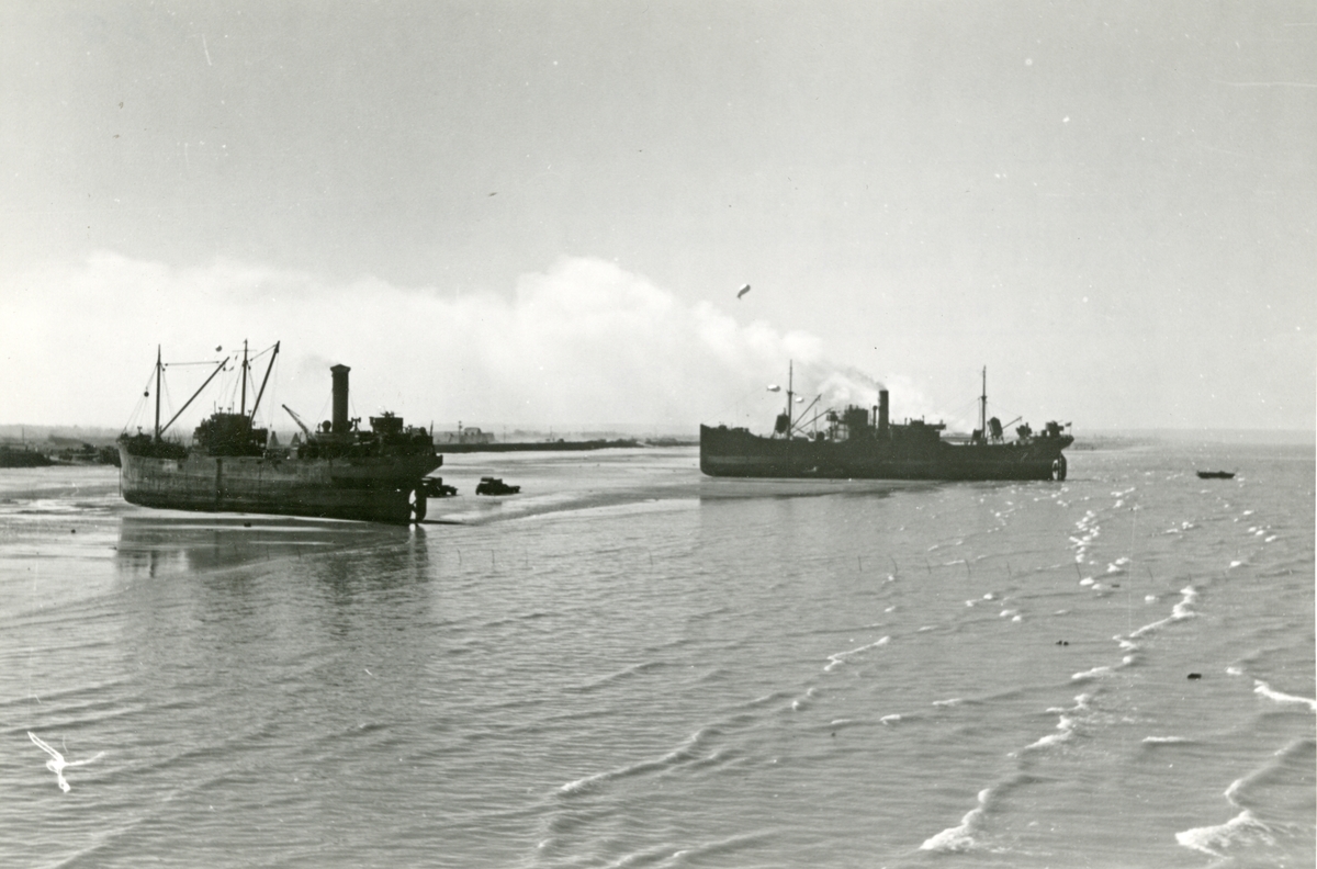 Dampskipene 'Heien' og 'Vestmanrød' (t.h.) fotografert under lossingen av forsyningene til det amerikanske frontavsnittet i Normandie under 2. verdenskrig