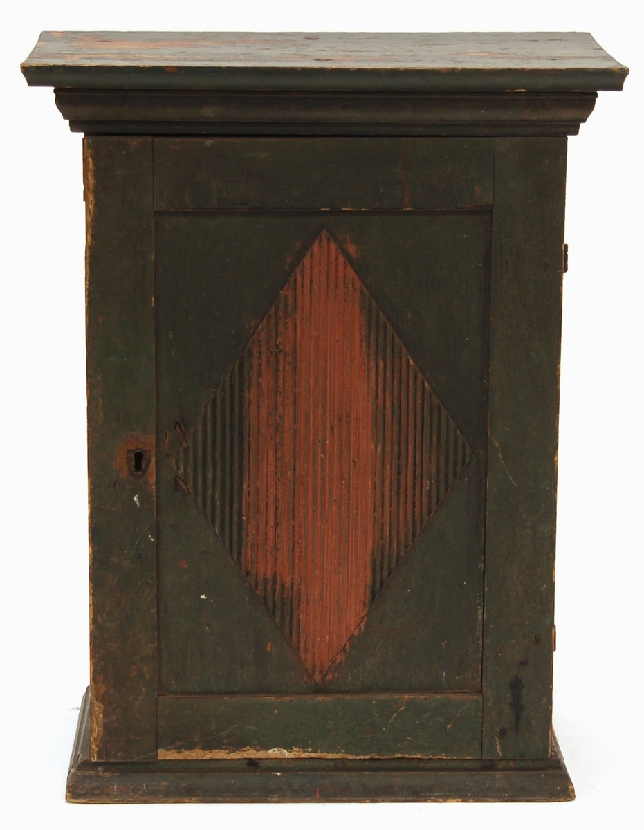 Hängskåp, helt grön (röd undermålning framträder på dörren).