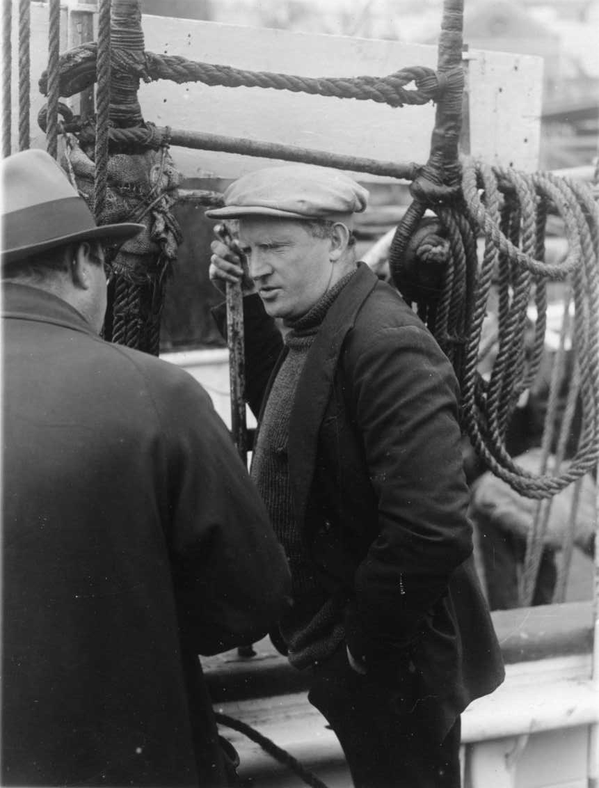 Två okända män på ett fartygsdäck samtalar med varandra.