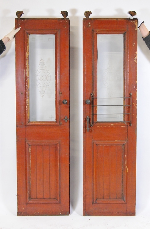 Ett par skjutdörrar med glasfönster. Båda dörrarna har "HdSJ" etsat i glaset samt dekorationer runt om. Den ena sidan av dörrarna är målad i vinrött och den andra har lackat trä. I toppen av dörrarna sitter två hjul. Den ena dörren (:1, vänster från utsidan) har knoppar på bägge sidor samt en ögla för låsning av handtaget och textilklädda sidor. Gallret framför glaset saknas. Den andra dörren (:2) har knoppar och handtag på båda sidor, ett galler som skydd framför nederdelen av fönsterrutan på den bemålade sidan och en askkopp nedanför handtaget på den lackade sidan. 

Obs! Måtten gäller den :2. :1 är något smalare pga. att den inte har en av listerna eller askkopp.