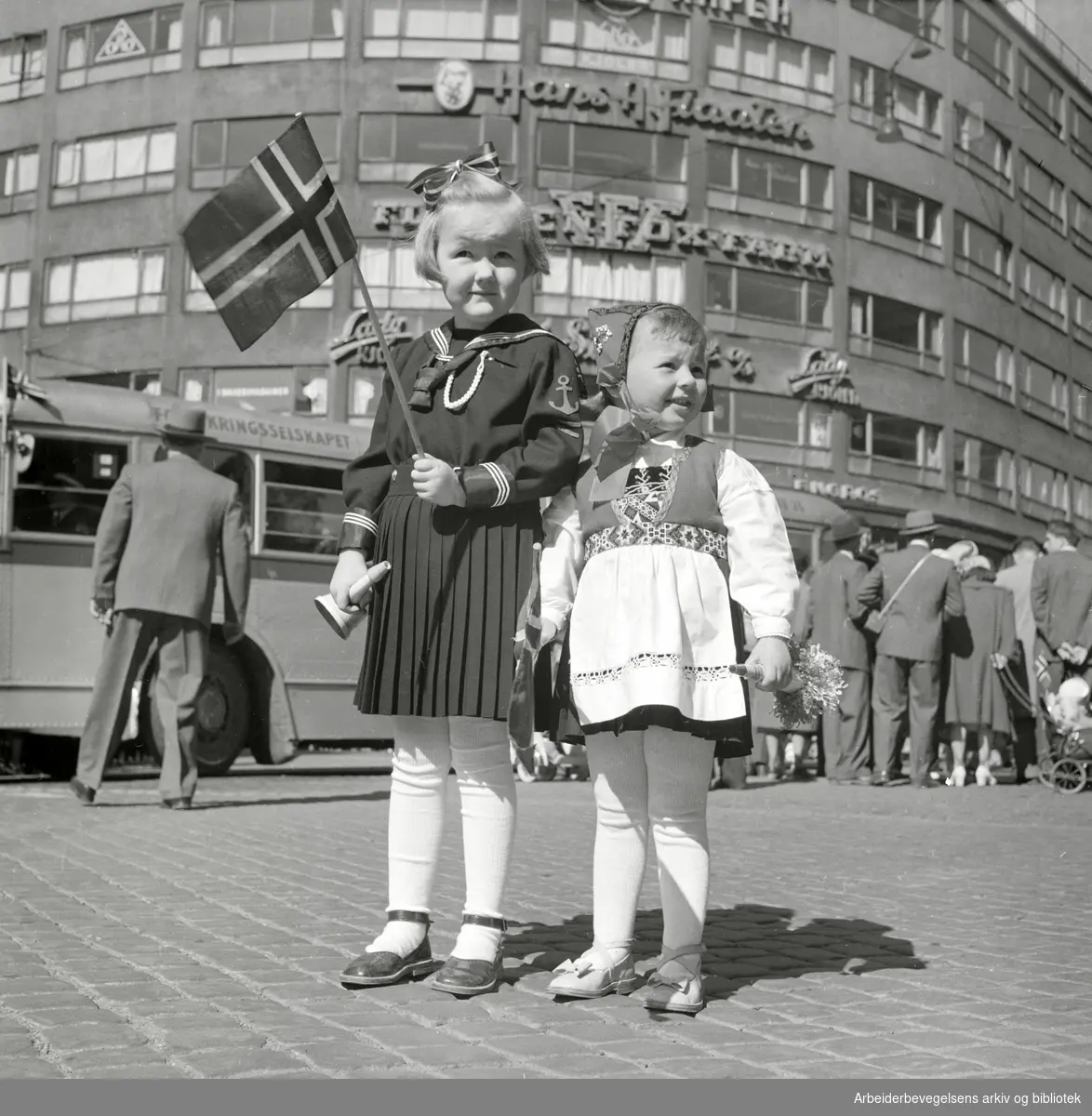 17. mai 1952. To små jenter med norske flagg utenfor Doblouggården i Dronningens gate.