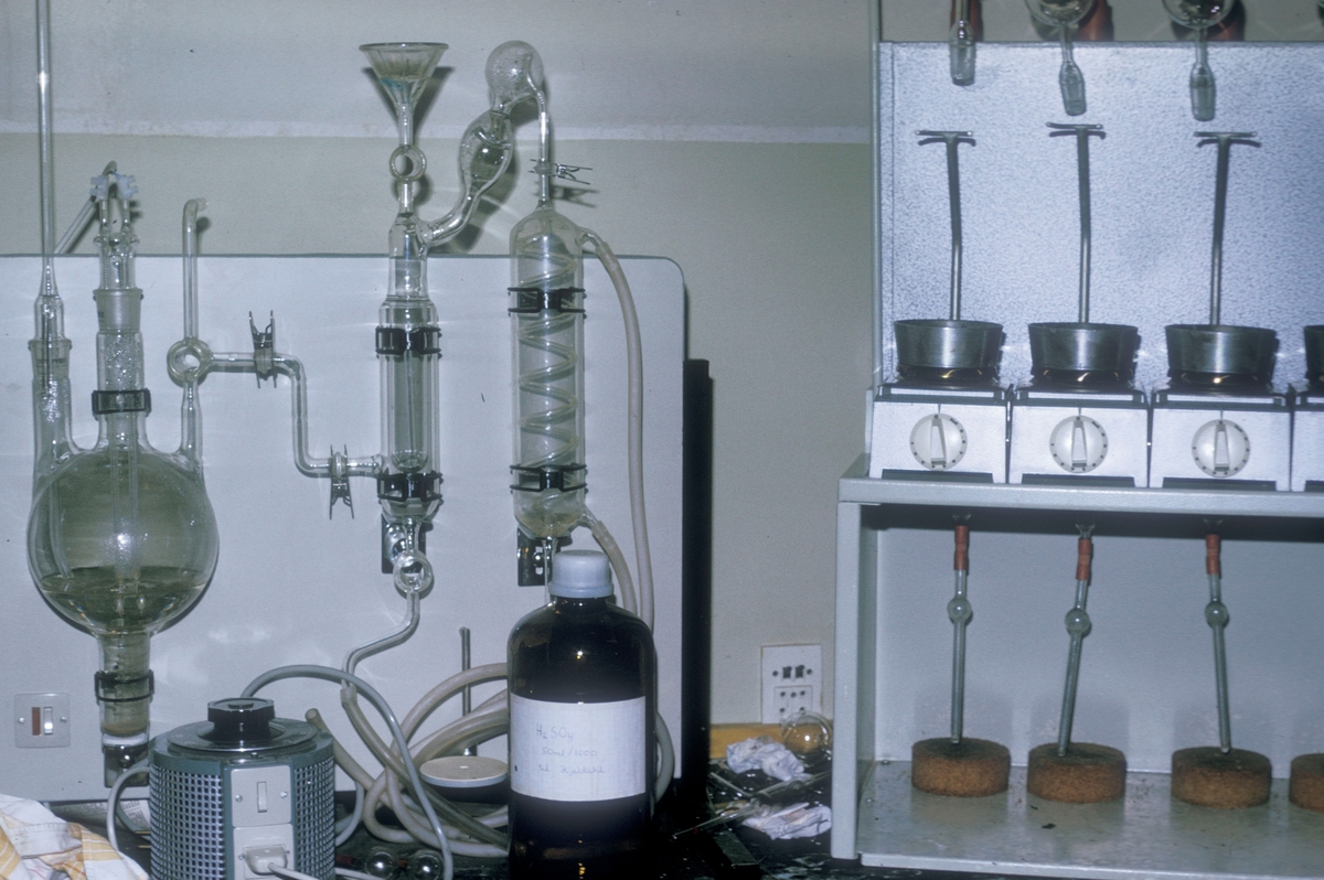 Et laboratorium med diverse apparater, glass og instrumenter på en arbeidsbenk.
