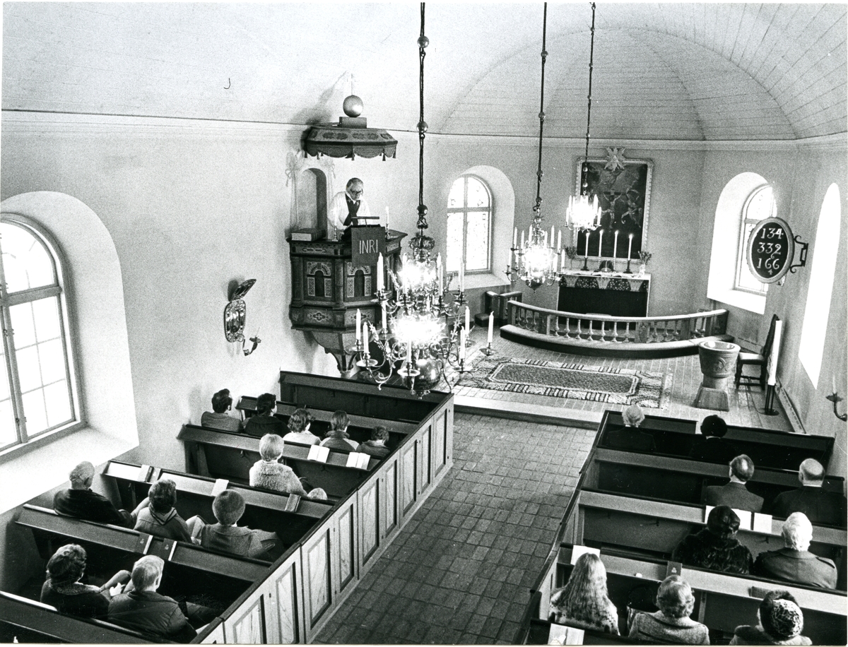 Lillhärad sn, Västerås.
Prästen håller predikan från predikstolen i Lillhärads kyrka.
Kyrkobesökarna sitter i kyrkbänkarna.