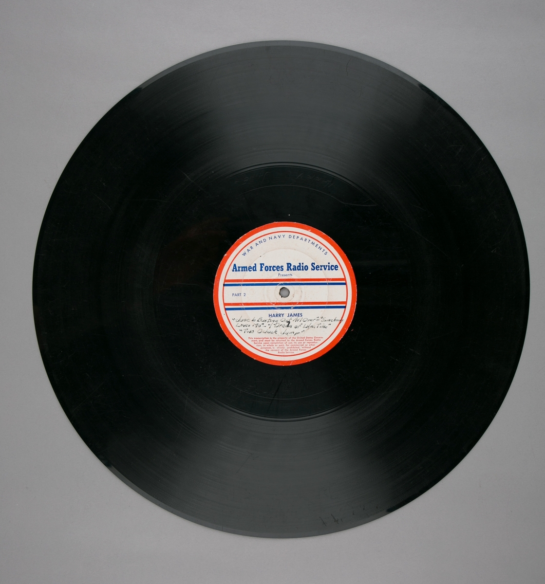 Grammofonplatesamling. LP-plate med tittel "Armed Forces Radio Service" utgitt av War and Navy Departements. Plate i svart vinyl spilles på platespiller med 33 1/3 omdreininger i minuttet (33-plate).