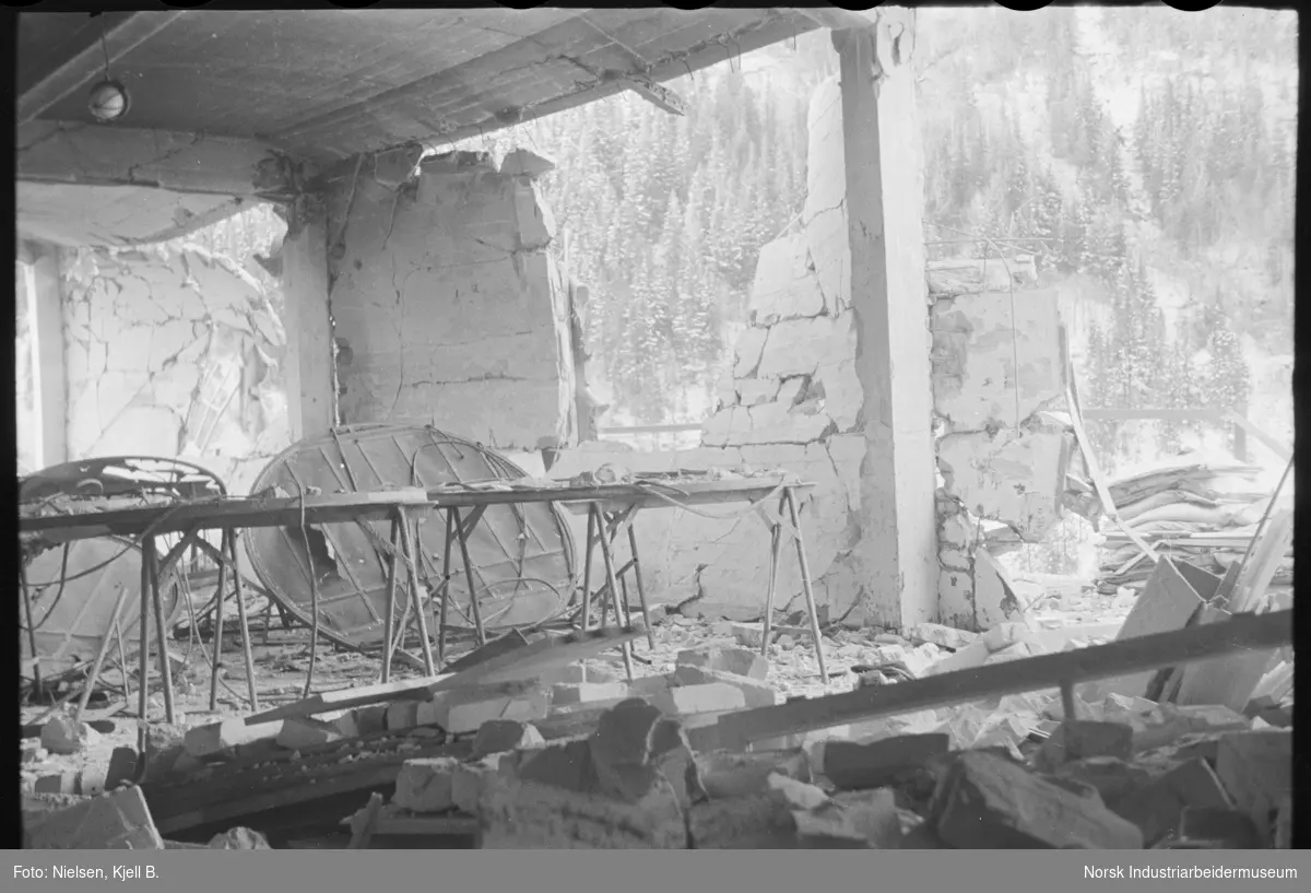Innvendige ødeleggelser på hydrogenfabrikkens øverste etasje (Vannstoffen) på Vemork etter alliert bombing 16. november 1943. Store hull i vegg og diafragmaer som ligger løst på gulv.