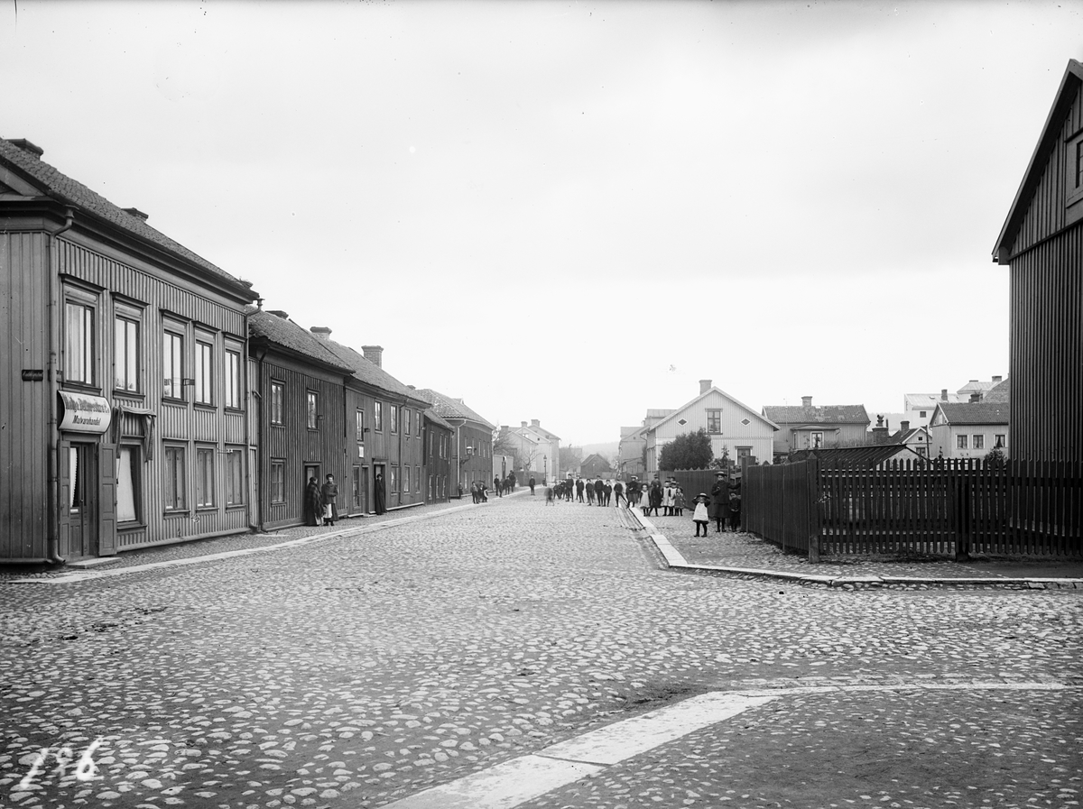 Slottsgatan mot öster från Änkhusgatan. Till vänster syns skylten till Helga Petterssons Matvaruhandel med gatuadress Slottsgatan 25. Till höger låg senare Lindells Vågfabrik.