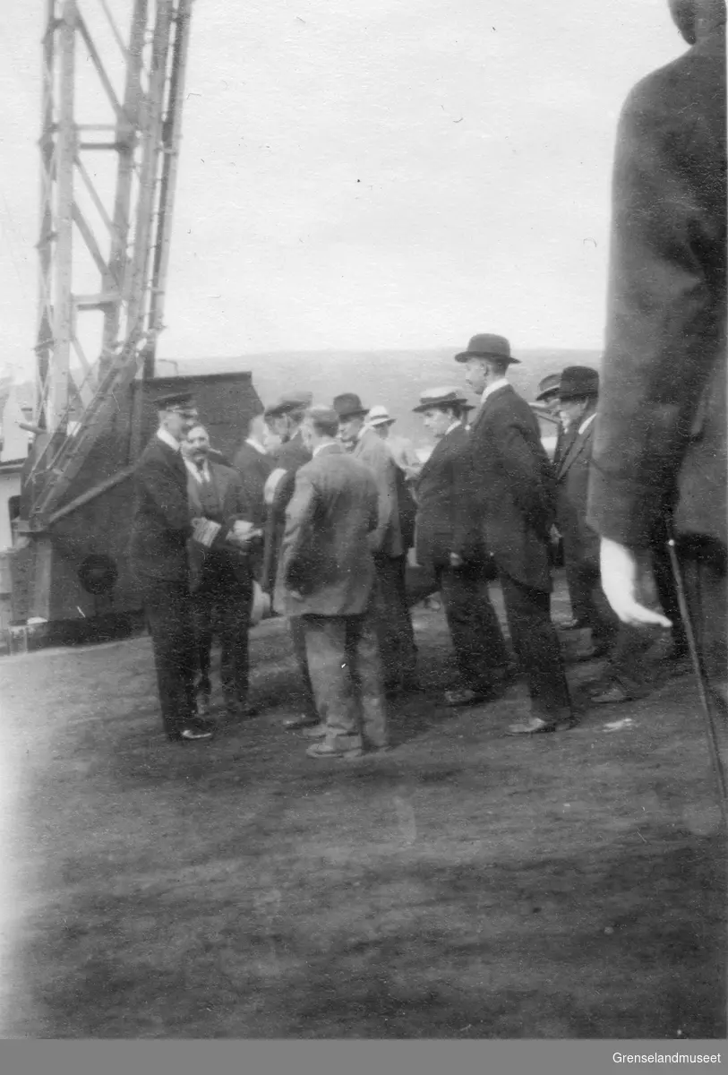 Hans Majestet Kong Haakon VII på kongebesøk i Kirkenes, sannsynlisgvis i juni 1922. Kongen hilser på mennesker på kaia.