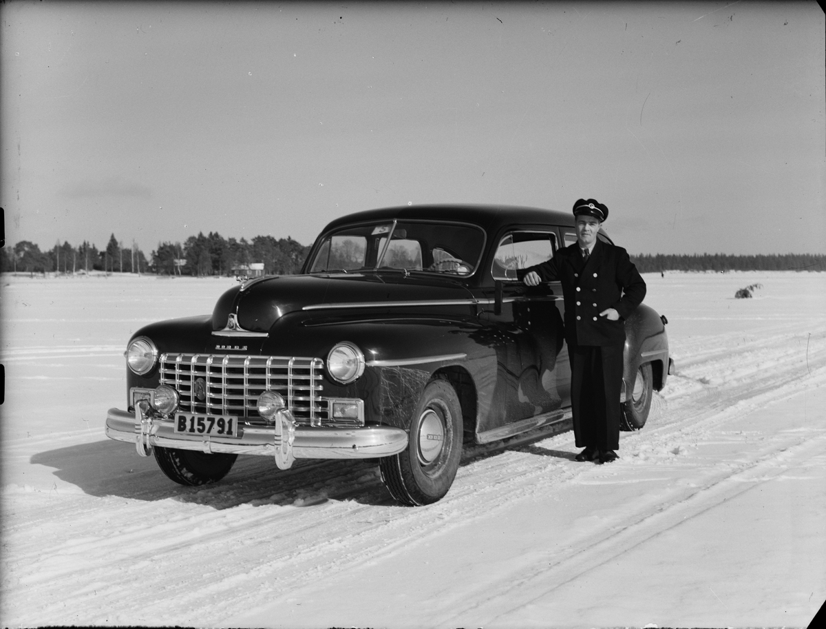 Chaufför vid sin bil på isen vid Östhammars hamn, Uppland