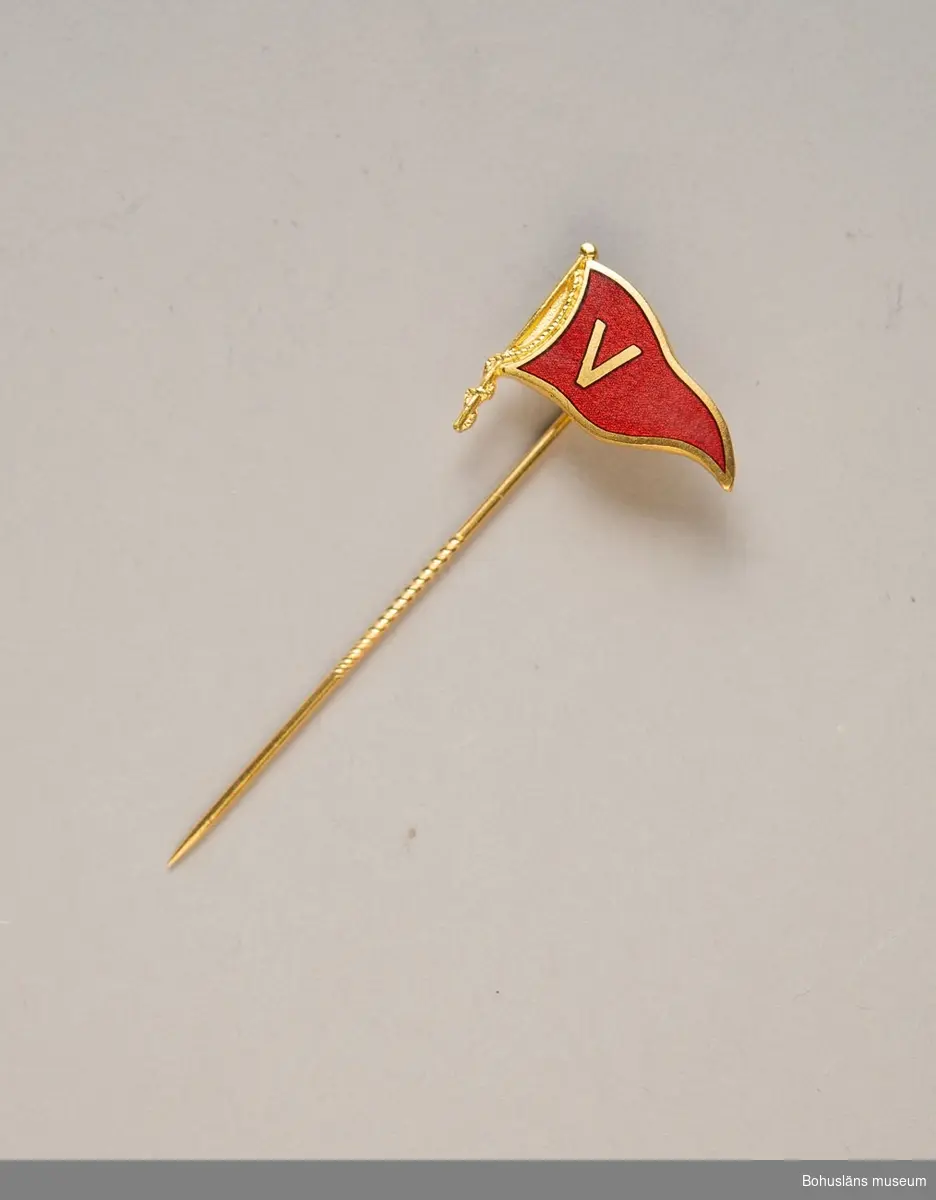 Två kartor med klubbnål för Segelsällskapet Viken, Uddevalla, den ena med sex och den andra med åtta nålar. Märket i form av vimpel i rött med guldfärgat V, vilket är sällskapets symbol. Förvaras i UM023566:1.