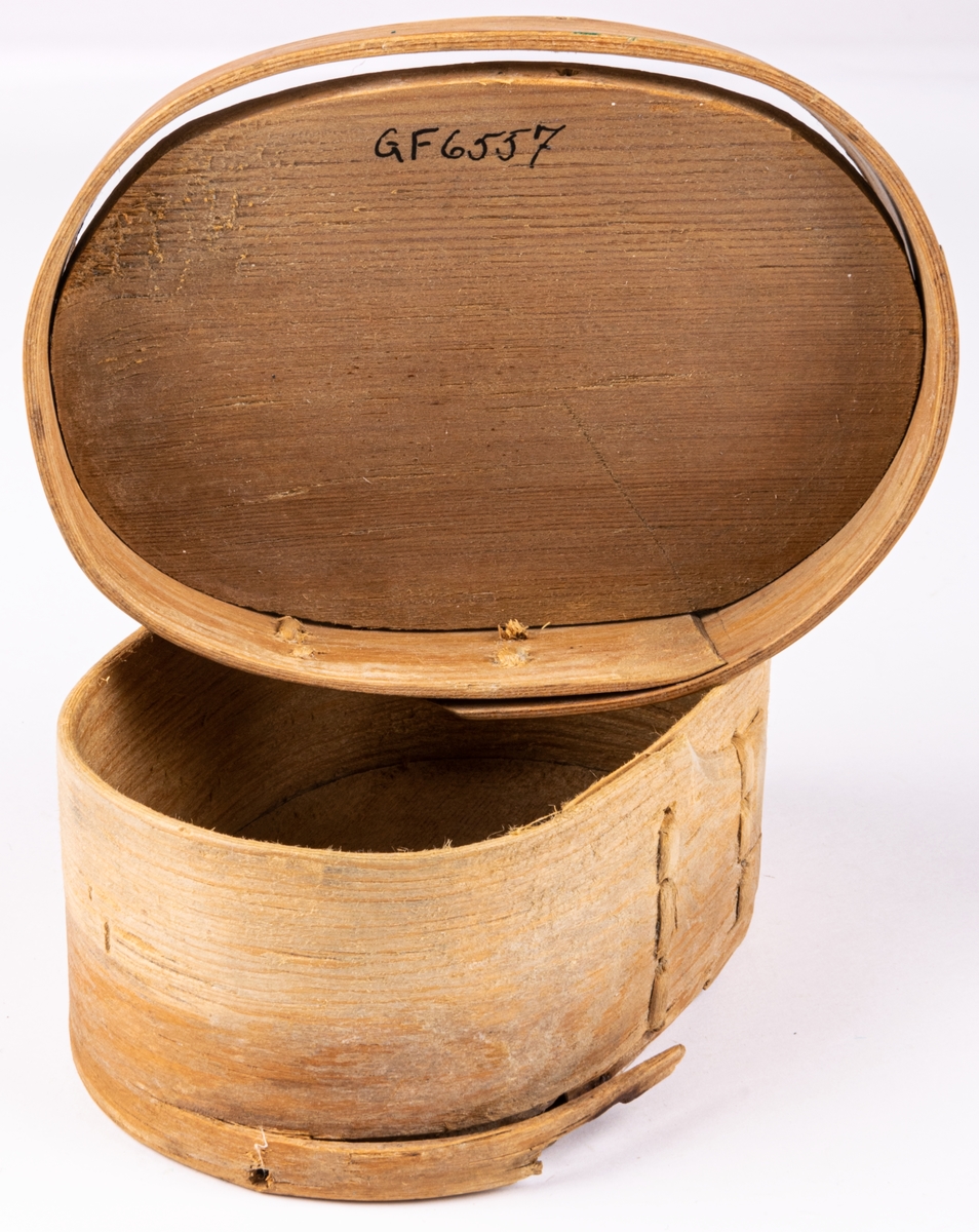 Ask, av trä, platt låda som öppnas med klaff på smalsida. Prydd med karvsnitt, sex-uddastjärnor, rosor m.m.
Kan ha använts för tobak.