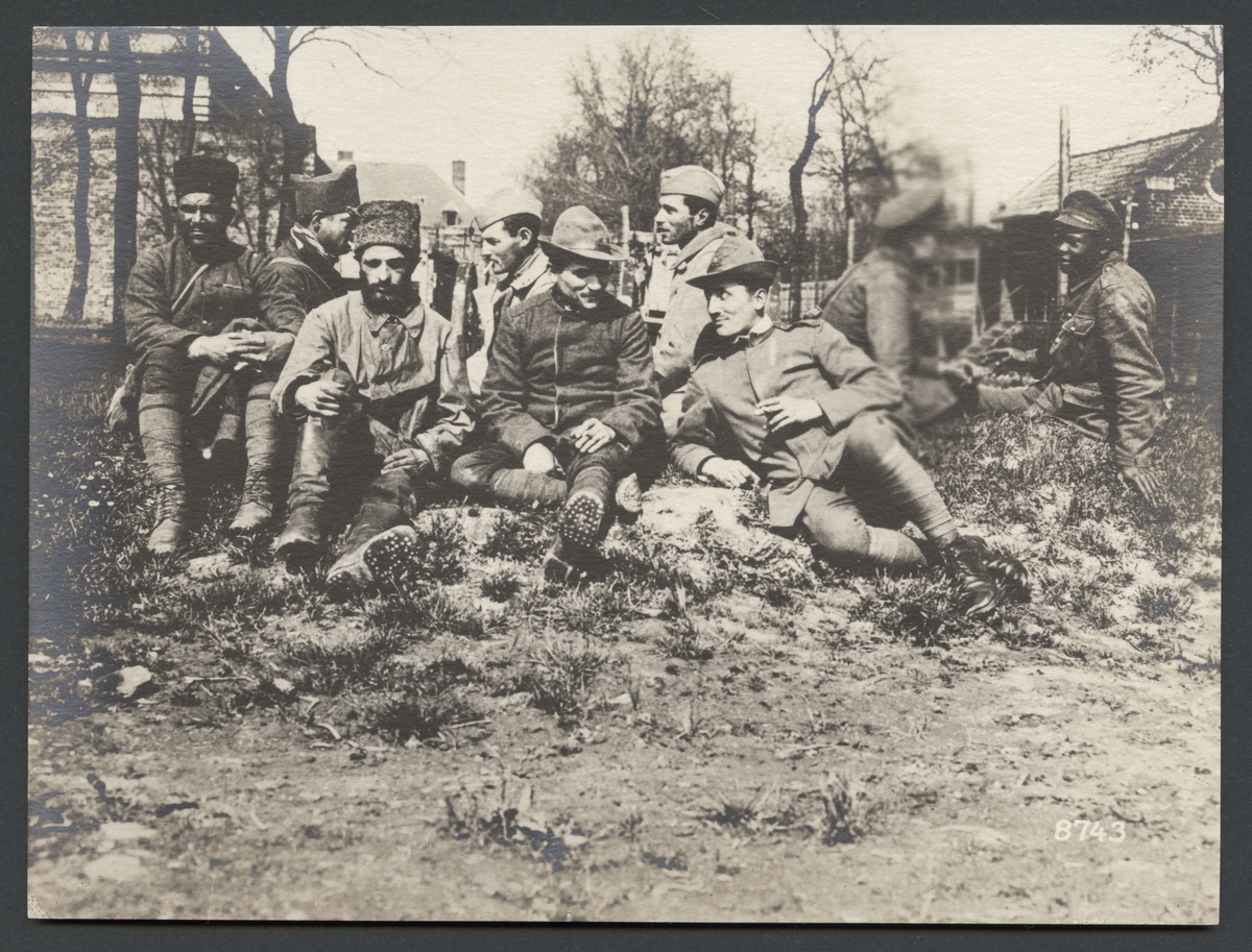 Bilden visar tillfångatagna allierade soldater som sitter på marken och väntar.

Originaltext: "I striderna vid Albert tillfångatagna amerikanare, fransmän, vita och färgade engelsmän.