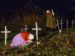 Sørgende kvinner blant hvite kors på kaupangens kirkegård.