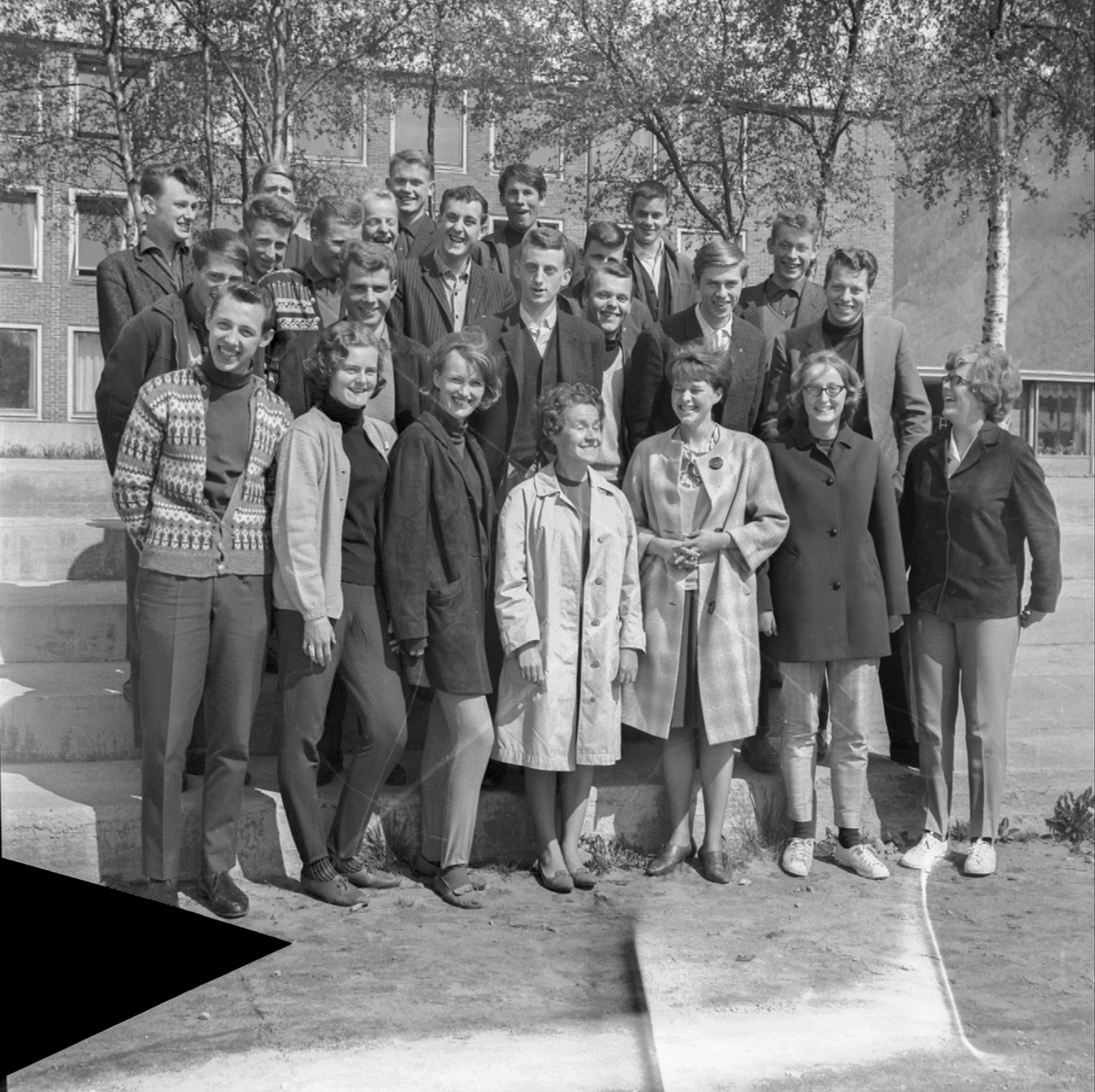 Klasse 1r realfaglinja på Odda Gymnas i 1963/64 med miss Miller framføre Odda høgre skole.