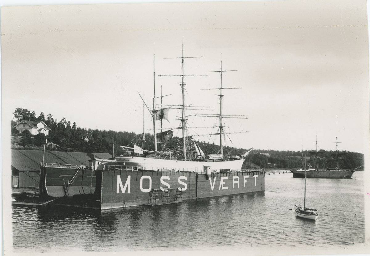 To bilder med samme motiv. Fotograf har sittet i en båt.
Detaljer: Begge flytedokkene til Moss Værft.
Historikk: Flytedokkene ble kjøpt fra Sandefjord 12. april 1899.
