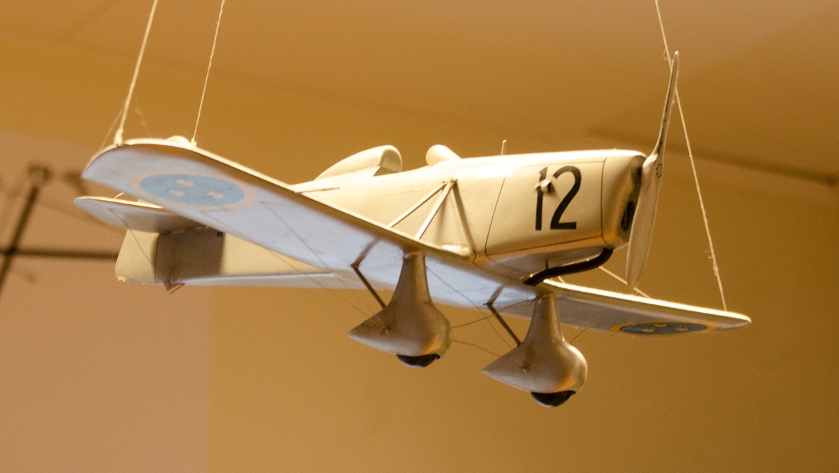 Flygplanmodell av trä i skala 1:20. P 1 Sparmanjagaren. Modellen är märkt med svarta siffror nr 12 samt flottilj- beteckning F 13. Modellen saknar propeller.