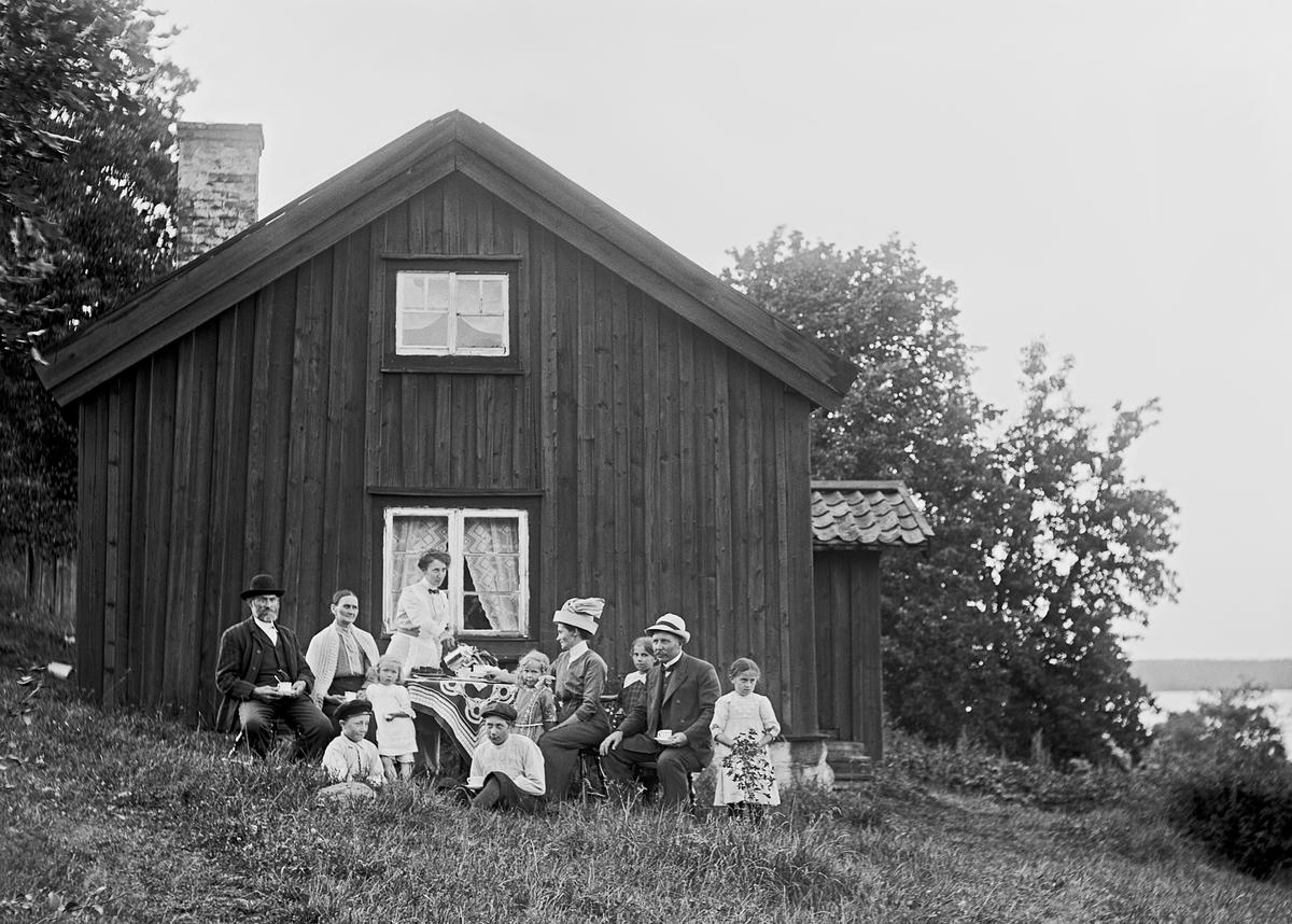 Sammankomst i Kornudden, Börrum socken. Enligt uppgift sitter Viktor Jönsson i Finnkroken längst till vänster och Agnes Fredriksson ses stående med kaffekanna i handen. Hennes identitet har inte kunnat styrkas.
