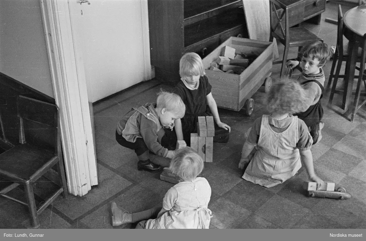 Motiv: H.S.B.s hus med lekstuga Vargentinsg. 5, Baltzar von Platensgat. 7 (HSB);
Ett barn gråter och tröstas av en kvinna, en kvinna matar ett barn, barn leker med träleksaker, barn leker i en sandlåda.

Motiv: H.S.B.s hus med lekstuga Vargentinsg. 5, Baltzar von Platensgat. 7 (HSB);
Ej kopierat.