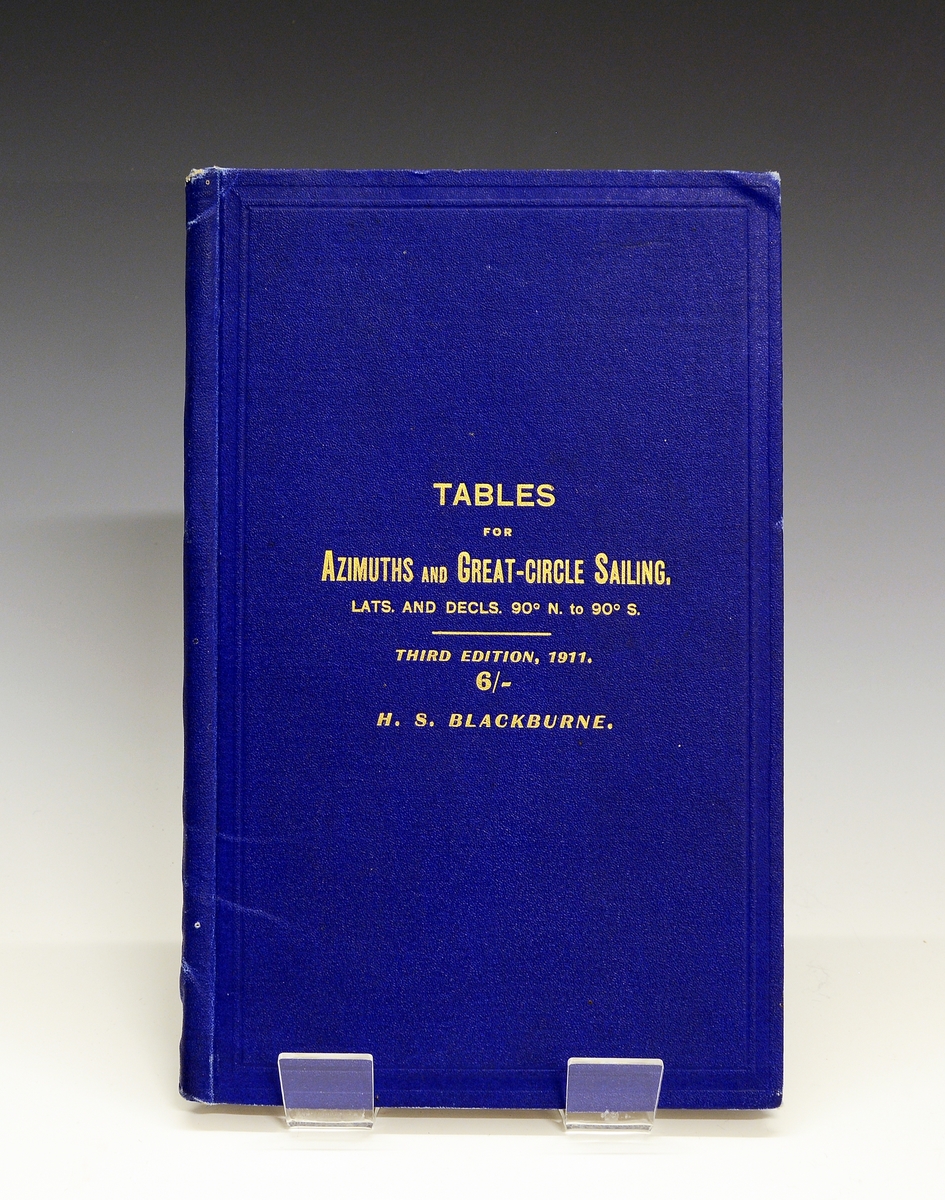 Navigasjonsbok med dypblå perm, og gravert tekst i gull på forsiden. På innsiden en dedikasjon til Roald Amundsen fra bokens forfatter.
