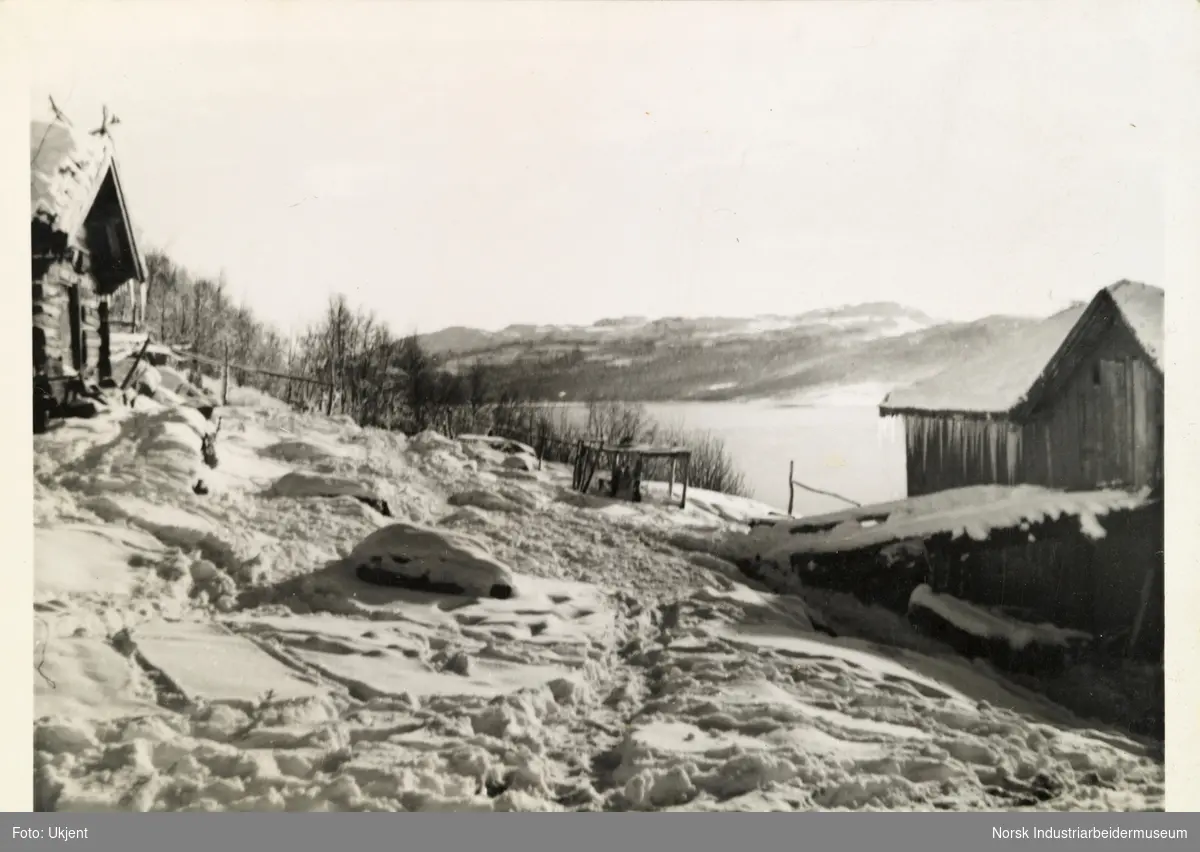 Snø på Skinnarland, Møsstrond. Gårdstun, hus og låve. Utsikt mot innsjøen Møsvatn