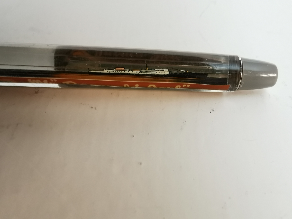 Plastikk penn med modell av M/S "Ragnvald Jarl" flytende frem og tilbake inne i pennskaftet. Metall hempe for å feste i pennen til eventuelt en lomme. Nede på pennen kan du skru pennspissen ut og inn.