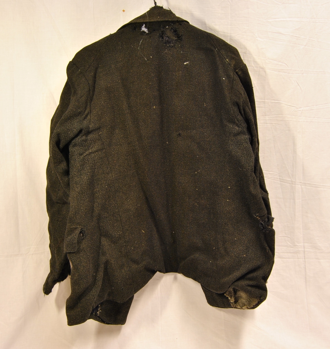 Form: blazerformet jakke med knapper i front og lommer i sidene. Meget slitt og lappet flere ganger. En del hull (møll/mus?)