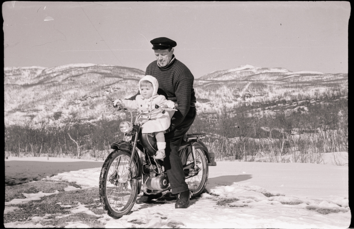 Mann og en liten unge på moped.
